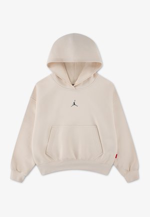 Beżowa bluza z kapturem, przednia kieszeń typu kangur i małe czarne logo Jumpman na środku klatki piersiowej, prezentowana na jednolitym tle.