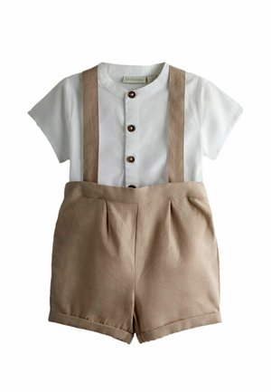 Camisa blanca de mangas cortas con tres botones marrones combinada con pantalones cortos beige de tiro alto con tirantes incorporados.