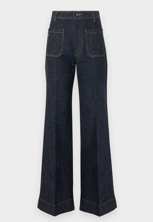 Tumedast teksast laiade jalgadega püksid, millel on silmatorkavad õmblused, nööpkinnitus ja kaks tagataskut. Iseloomustab klassikaline kõrge vöökohaga disain.