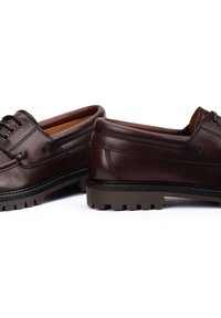 Chaussures en cuir marron avec une finition lisse, design à lacets et semelle en caoutchouc texturée avec des crampons pour l'adhérence. Détail de logo subtil sur le côté.