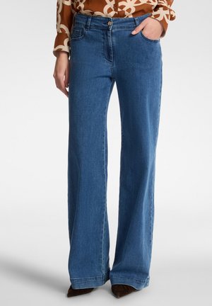 Jeans a gamba larga in denim blu, caratterizzati da un'alta vita, tasche anteriori e chiusura con bottone. Il tessuto ha una consistenza liscia.