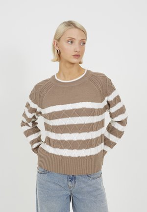 Maglione lavorato a maglia marrone con strisce orizzontali bianche, caratterizzato da un motivo a rombi testurizzato e orlo a costine. Abbinato a jeans azzurri chiari.