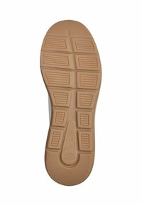 Rubber shoe sole with a textured, tan surface featuring multiple grooves and raised sections for traction and shock absorption.