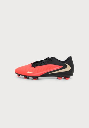 Chaussure de football Nike noire et rouge avec logo swoosh beige et lacets noirs sur fond blanc, vue de côté.