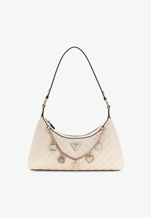 Cremfarbene gesteppte Handtasche mit geschwungener Silhouette, schwarzem Rand, goldfarbenen Beschlägen, Kettenakzenten und dekorativen Charms, darunter ein Schloss und eine Blume.