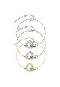 Quattro braccialetti in argento, oro rosa e oro giallo. Ognuno presenta un fermaglio a forma di cuore con accenti di strass. I collegamenti della catena variano nello stile.