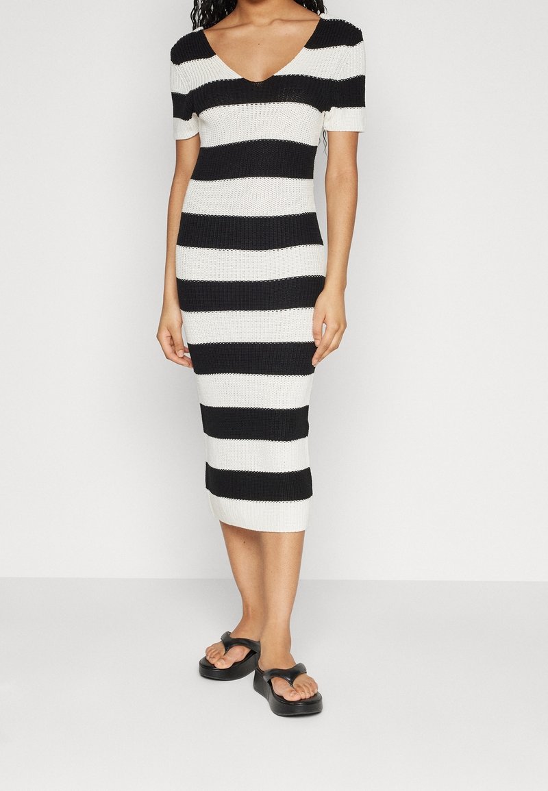 Strick-Midi-Kleid mit V-Ausschnitt, das abwechselnd schwarze und weiße horizontale Streifen aufweist. Kurze Ärmel und gerippte Textur.