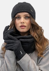 Sort strikket beanie, handsker og tørklæde sæt. Handskerne har en tekstureret finish med en sølvaccent. Varme, bløde materialer i et koordineret design.