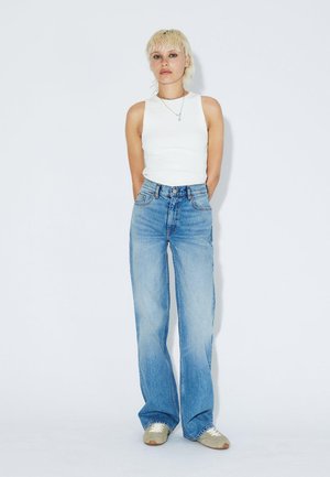 Široké modré džíny z denimu s vysokým pasem, s vybledlým praním a pěti kapsami, doplněné o přiléhavý bílý tílko.