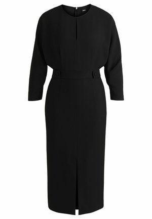 Zwarte jurk met lange mouwen, ronde hals, tailleband en een voorkeursplit. Gemaakt van een soepele stof met minimale details.