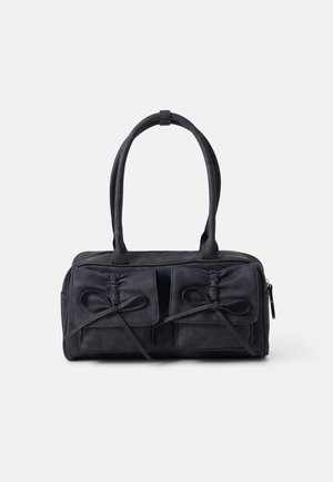 Sort rektangulær håndtaske med to forlommer sikret med bundne stropper og to runde håndtag mod en ensfarvet baggrund.