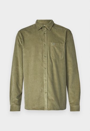Camisa de corduroy verde-azeitona com frente de botões, mangas longas, colarinho pontiagudo e um bolso no peito com um pequeno logótipo.