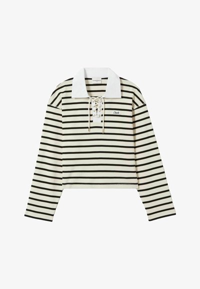 Top de manga larga a rayas en crema y negro, con un cuello blanco y un frente con cordones. Presenta un diseño corto y un pequeño logo en el lado izquierdo del pecho.