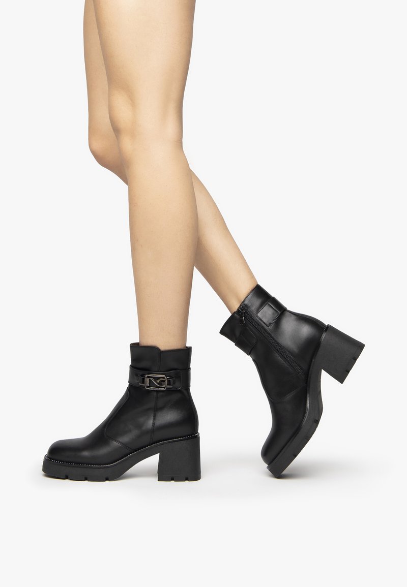 Black leather ankle boots with a chunky heel, featuring a buckle accent and a side zipper, on a plain white background.
