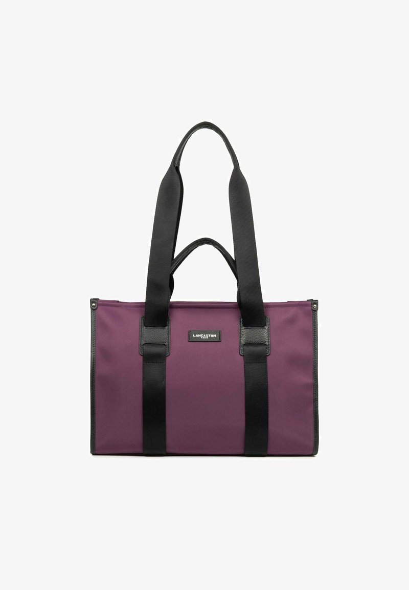 Borsa a spalla in tessuto viola con manici neri e dettagli in pelle. Presenta una forma rettangolare e un'etichetta con il marchio sul davanti. Texture liscia.