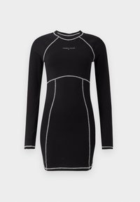Robe noire à manches longues avec une silhouette ajustée. Présente des coutures argentées contrastantes et un col rond. Logo sur la poitrine.