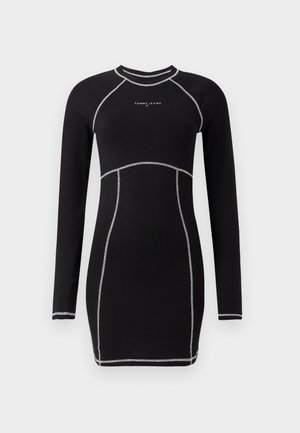 Robe noire à manches longues avec une silhouette ajustée. Présente des coutures argentées contrastantes et un col rond. Logo sur la poitrine.