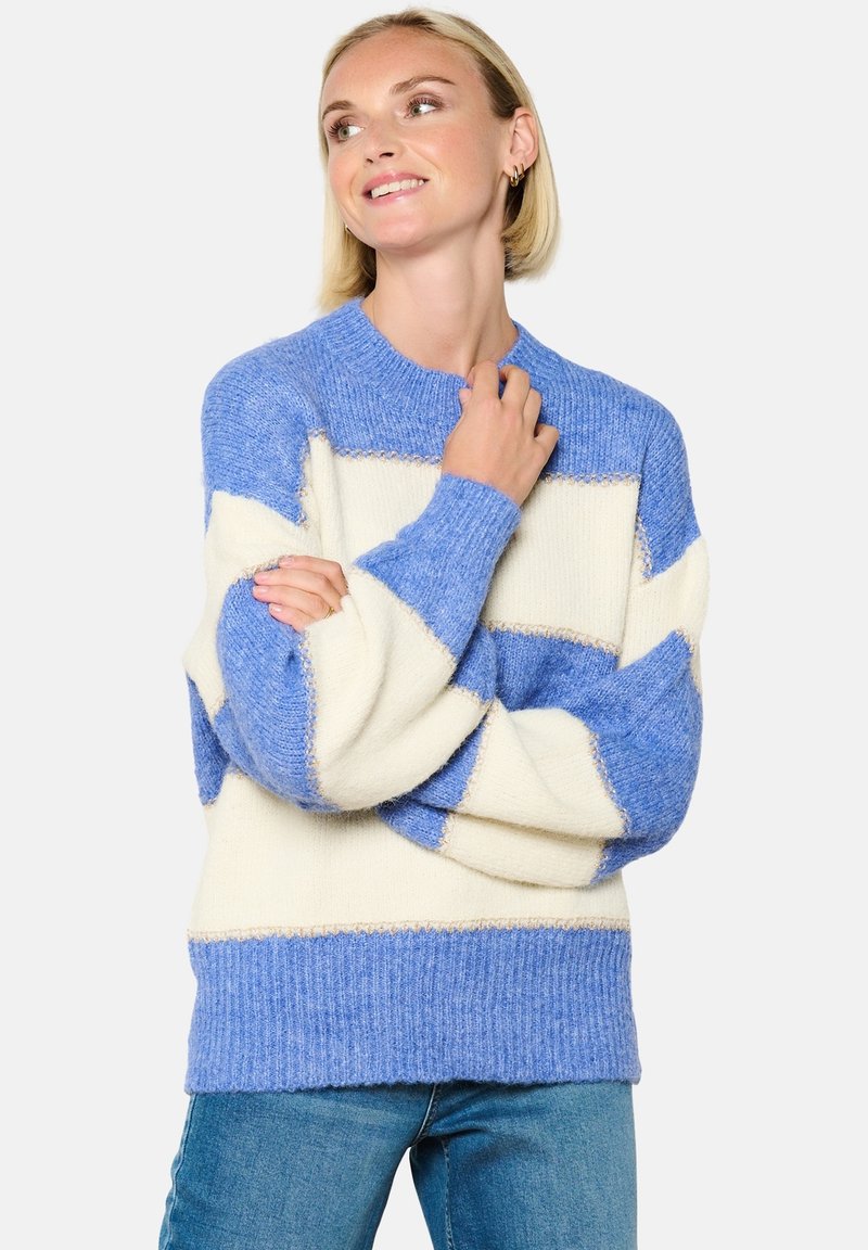 Kootud sviiter siniste ja kreemjate triipudega, soonikuga varrukas ja hem, valmistatud pehmest lõngast, ümmarguse kaelusega ja lõdva lõikega.