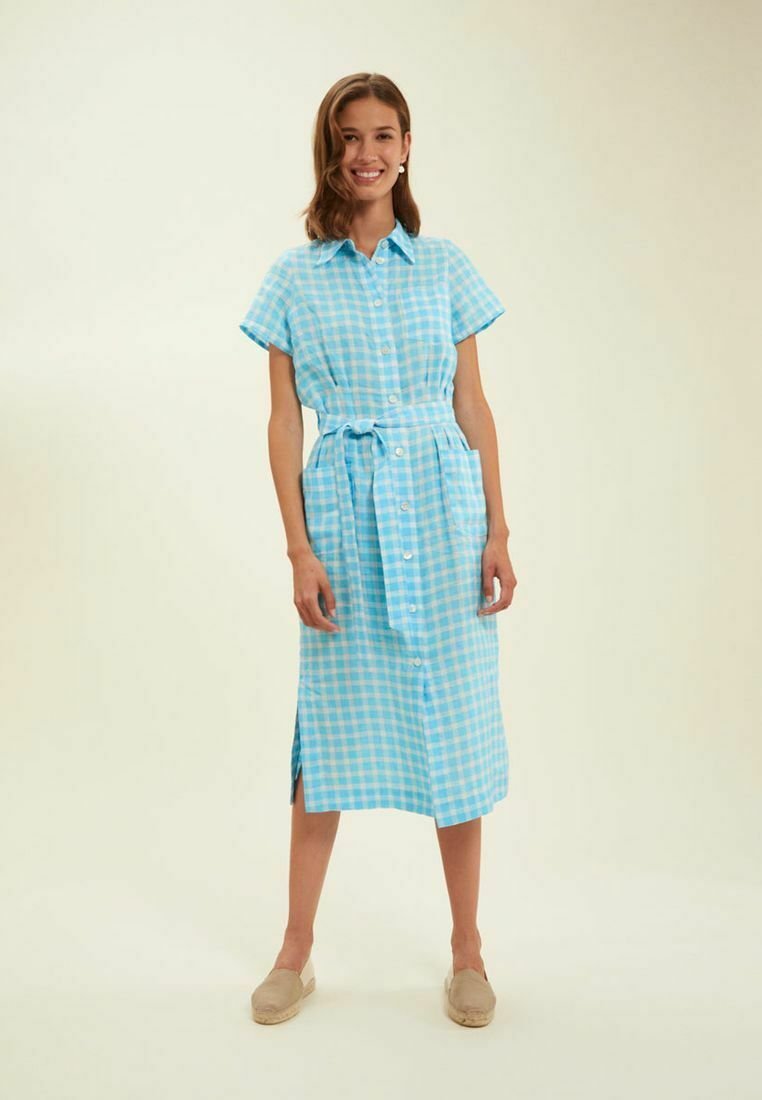 Robe chemise à carreaux bleus avec des manches courtes, fermeture à boutons sur le devant, ceinture à la taille et fentes latérales. Fabriquée en tissu léger, idéale pour un style décontracté.