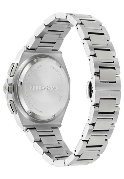 Rozsdamentes acél karóra nyolcszögletű tokkal, matt és polírozott felületekkel, zafír kristállyal, és téglalap alakú szemekből álló láncszemes szíjjal.