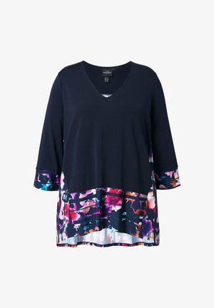 Granatowa bluzka z dekoltem w serek i długimi rękawami, z kolorowym kwiatowym wzorem na mankietach i obszyciu, o luźnym kroju i lekkim materiale.