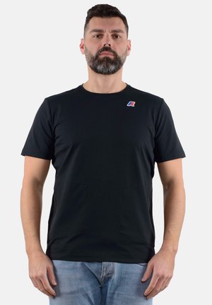 T-shirt nera a maniche corte con scollatura rotonda, due tasche frontali e un piccolo logo colorato sul petto. Tessuto dalla superficie liscia.