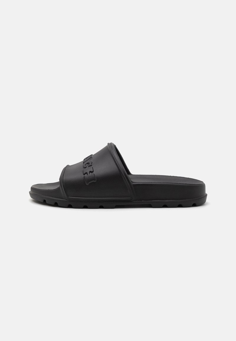 Black slide sandal made of rubber, featuring a textured strap with embossed lettering and a flat sole with small grooves for traction.