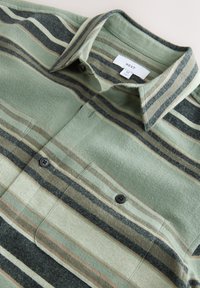 Green and beige striped button-up shirt with collar and chest pockets, size medium, label reading "NEXT" visible inside collar.
