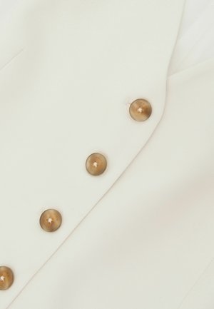 Weißer Blazer mit glatter Textur, ausgestattet mit sechs runden hellbraunen Knöpfen und einem maßgeschneiderten Design mit Revers.