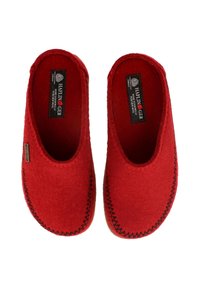Rote Wollslipper mit runder Form, sichtbaren Nähten entlang der Kante und einem kleinen Logolabel innen. Kuscheligweicher Filztextur.