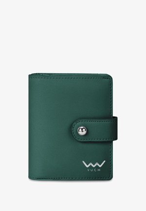 Grüne Lederbrieftasche mit Druckknopfverschluss, versehen mit einem Logo und glatter Oberfläche, in einer Hand vor einem Außenhintergrund gehalten.