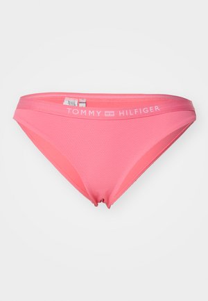 Lyserød bikinibund med en glat tekstur og en let glans. Har en mærket talje med "TOMMY HILFIGER" i hvid skrift.