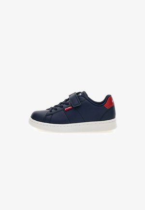 Scarpa da ginnastica blu navy con tomaia in pelle liscia, suola in gomma bianca, design con lacci e cinturino sul collo del piede con un accento rosso.