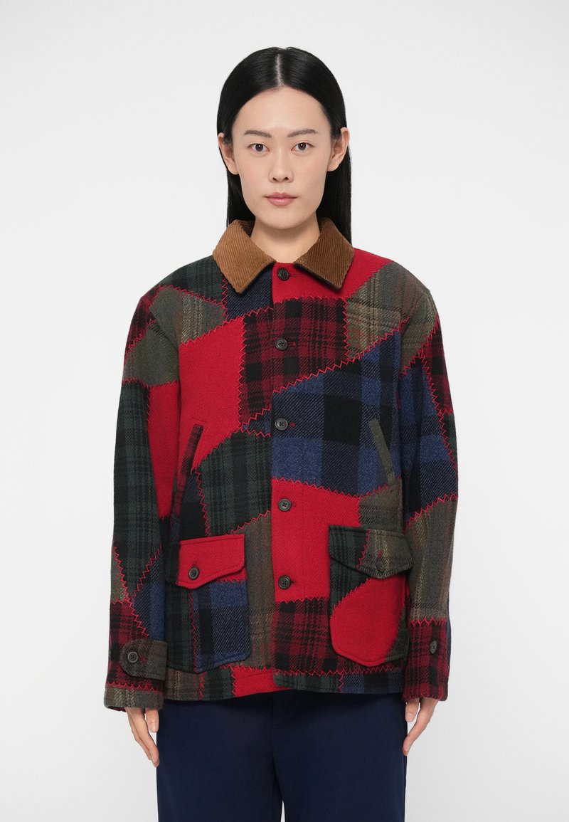 Καρό μπουφάν πατςγουόρκ με κόκκινα, πράσινα και μπλε καρό μοτίβα, καφέ γιακά από κοτλέ και δύο εμπρόσθιες τσέπες με κούμπωμα κουμπιού.
