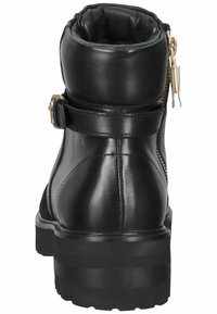 Svart läderankelboots med dragkedjestängning och remdetalj. Sulan är kraftig med synligt mönster för grepp. Slät textur överlag.