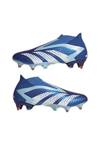 Blå fotbollsskor med en elegant design, som har en texturerad ovandel, vita accenter och en genomskinlig sula med röda dobbar.