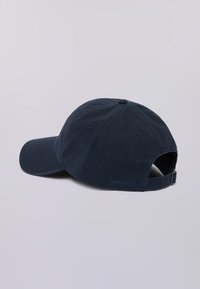 Gorra de béisbol de algodón azul marino con visera curva, correa ajustable y pequeño logo azul en la parte trasera. Textura suave con ventilaciones tipo ojal.