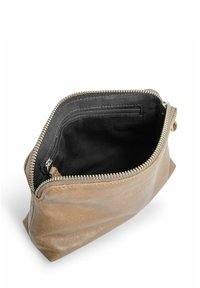 Rjava usnjena torbica z zadrgo. Notranjost je obložena s črnim materialom in vsebuje majhen žep z zadrgo za organizacijo.