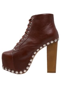 Botín de tobillo de plataforma de cuero marrón con cordones en la parte delantera, tacón alto y detalles de remaches plateados a lo largo de la suela. Textura suave.