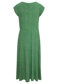 Vihreä mekko, jossa on hihattomat hihat, avonainen takaosa, tiukka vyötärö ja A-linjainen hame. Mekossa on valkoinen pilkkukuosi koko ajan.