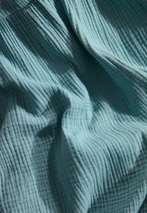 Tissu texturé et froissé en bleu sarcelle clair, présentant des lignes verticales et une qualité douce et respirante, adapté pour les vêtements ou les textiles d'intérieur.