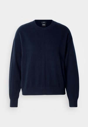 Pull en maille bleu marine foncé fabriqué en tissu doux. Il présente un col rond, des épaules tombantes et des poignets et un ourlet côtelés. Design simple sans motifs.