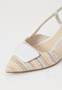 Zapato slingback de punta afilada en tejido multicolor, con un acento rectangular blanco en el empeine y un interior beige.