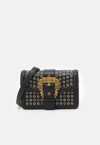 Borsa in pelle nera con hardware dorato, caratterizzata da occhielli metallici bianchi e dorati, e una chiusura decorativa con motivi di leone.