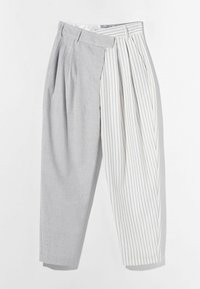 Šedé a bílé kalhoty s širokými nohavicemi; levá strana má kostkovaný vzor, pravá strana má vertikální pruhy, obě strany s sklady.