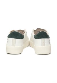 Sneakers bianchi in pelle con un inserto in suede verde-grigio sul tallone, punta rotonda e suola piatta in gomma, caratterizzati da un design minimalista e dettagli di cucitura.