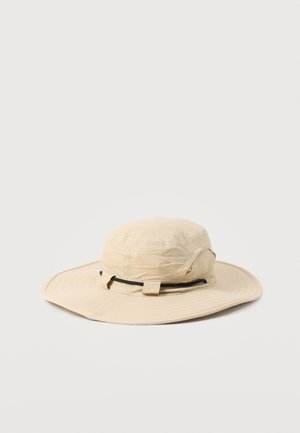 Beige zonnehoed met brede rand en een zwarte verstelbare koord rond de hoed, getoond tegen een effen lichte achtergrond.