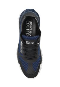 Baskets bleu marine avec texture en maille, accents noirs et semelle blanche. Présente un laçage à l'avant et un marquage sur la semelle intérieure et sur le côté.