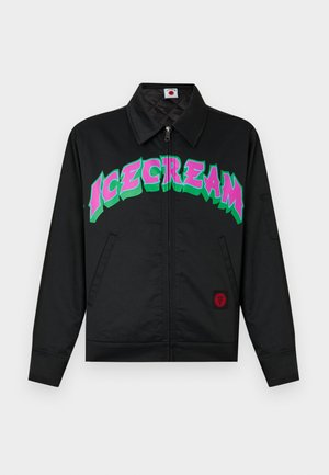 Veste noire à fermeture éclair avec col pointu, poches avant, et grand texte coloré "ICECREAM" en rose et vert sur la poitrine.