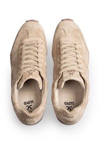 Beżowe zamszowe trampki na sznurowadła z teksturowaną podeszwą i logo "LLOYD" na języku oraz wewnętrznej podeszwie, widoczne z góry na białym tle.